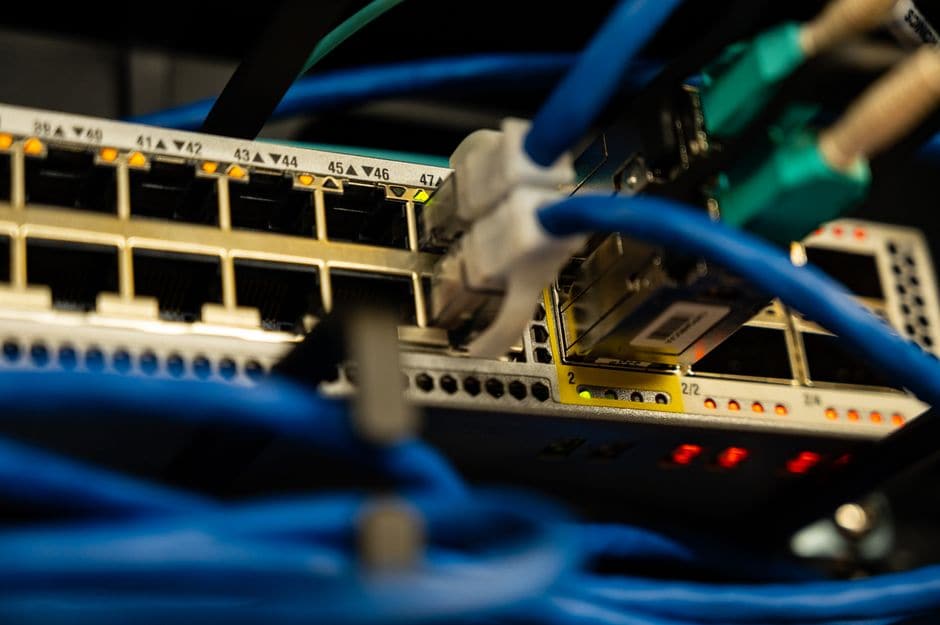 サーバーラックのネットワークスイッチに、多数のイーサネットケーブルが1台へ集約されて接続されている様子