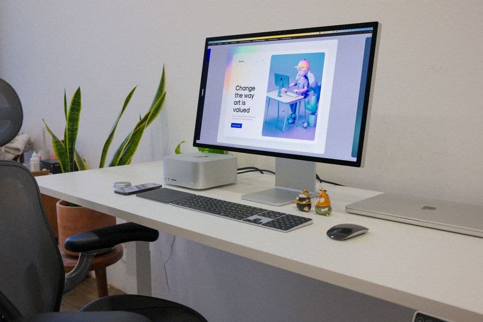 白いデスクに置かれたMac StudioとノートPC、モニターとキーボード