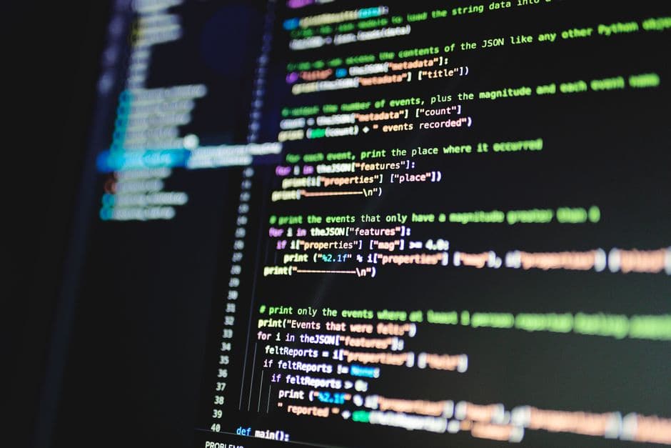 暗い背景に色分けされたプログラムのコードが表示されたコンピューターモニターの画面