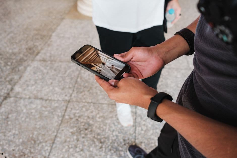 イメージ写真。手元のスマートフォンに表示された写真を確認している人の手元のクローズアップ。