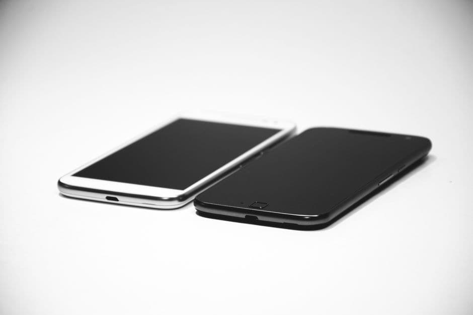 白い背景に置かれた、黒と白の2台のスマートフォン