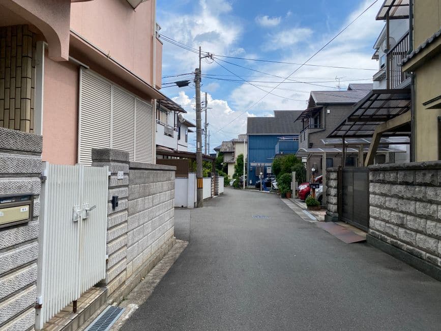 中央線のない、住宅街の細い道路の写真