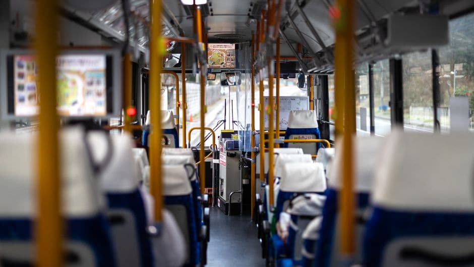 座席が整然と並ぶ、乗客のいない路線バス車内の写真