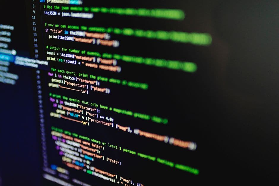 暗い画面に表示された、色分けされたプログラムのコード