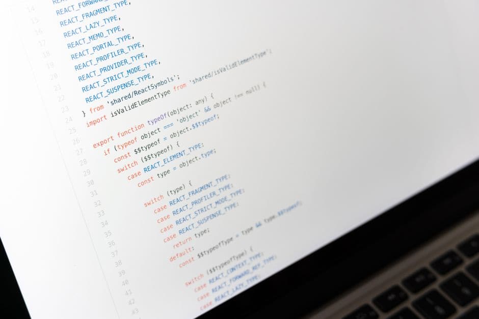 ノートパソコンの画面いっぱいに映る、色分けされたプログラムコードのクローズアップ