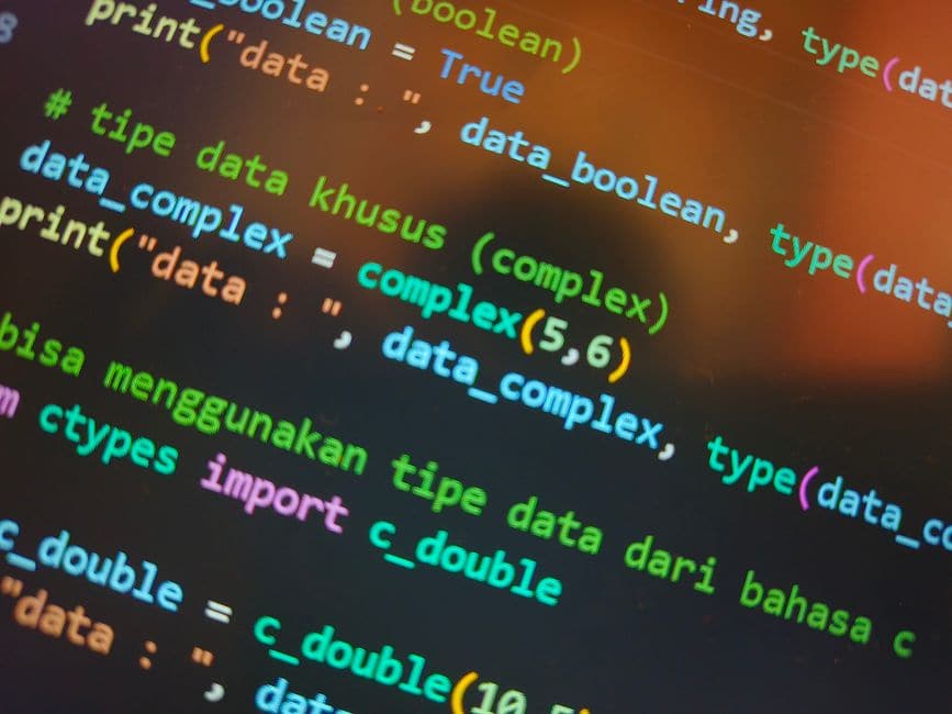 暗い背景のモニターに表示された、色分けされたプログラムのコード