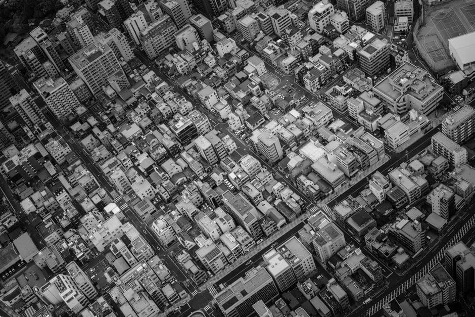 東京都心部をほぼ真上から撮った白黒の空撮写真。建物と道路が隙間なく密集して並んでいる