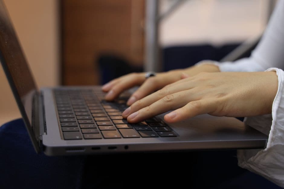 ノートパソコンのキーボードに両手を置いてタイピングしている様子